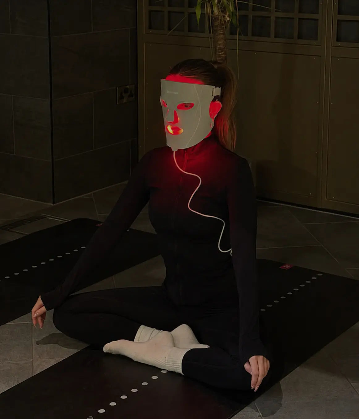 Cliente assise portant le masque LED 600 luminothérapie rouge en séance à domicile – Seoul Factory